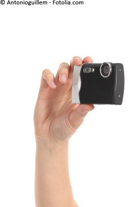 Beautiful woman hands holding a black compact camera